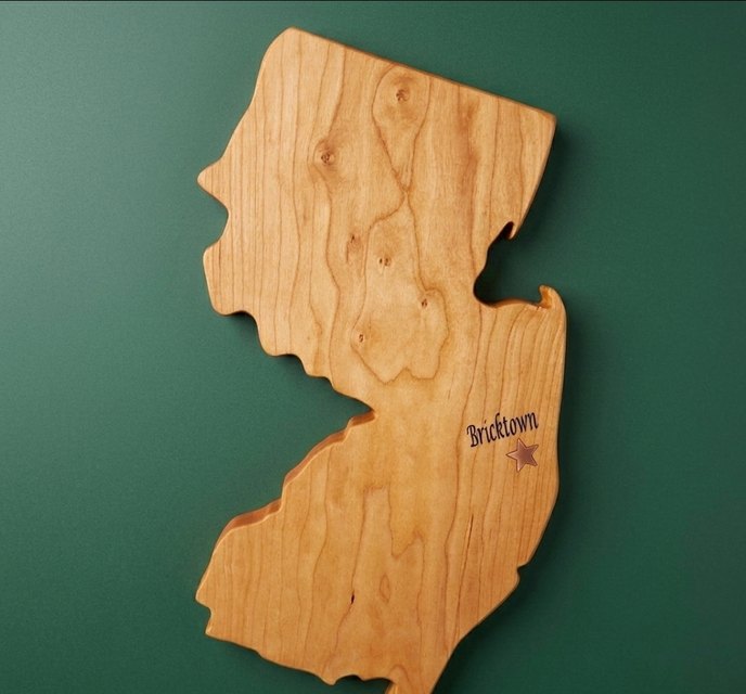 Cherry board cut in the shape of New Jersey with Bricktown engraved and marked by a star